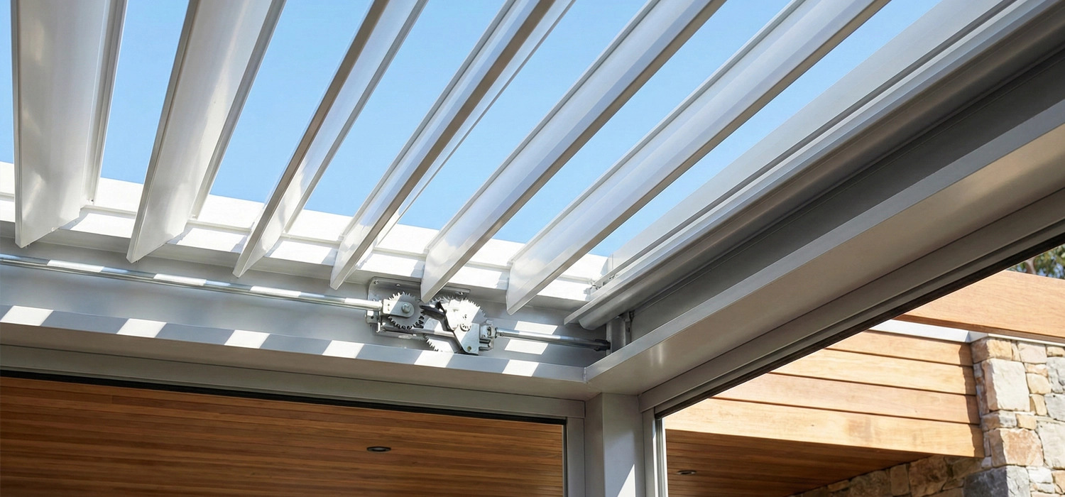 Close-up of adjustable louvre roof system, showing metal beams and opening mechanism in sunlight.