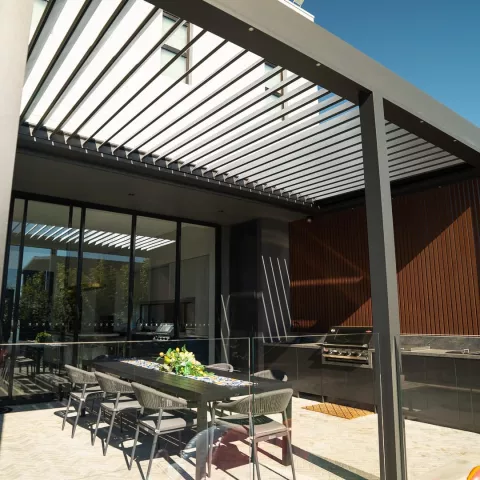Modern Australian home with a motorised opening louvre roof over an outdoor entertaining area.