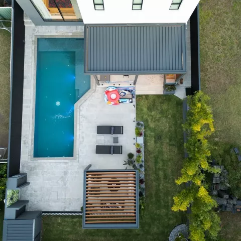Aerial view of a home featuring a Louvretec opening louvre roof and retractable louvre roof installed over two outdoor living areas