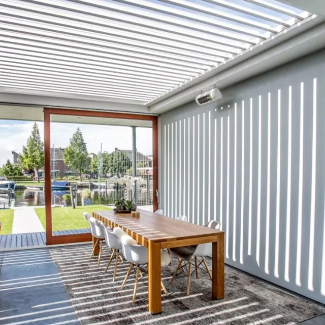 Modern outdoor area with a Louvretec motorized roof, offering flexible living by the sea.